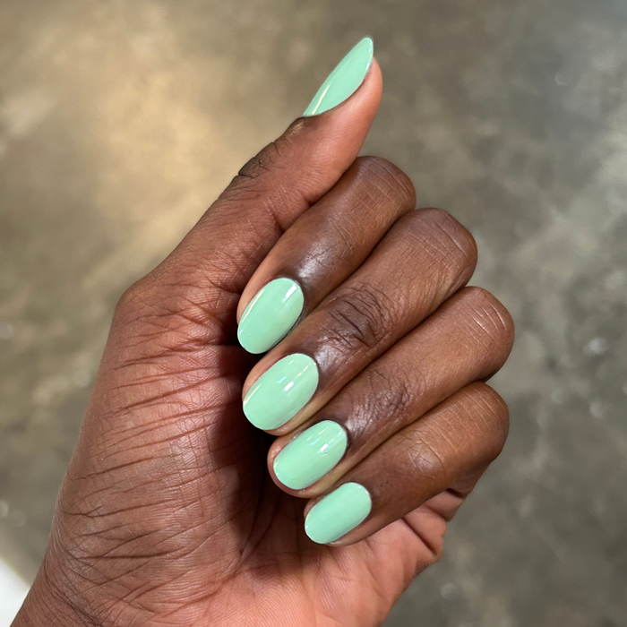 Hand showcasing nails painted with Aced It pastel green for a smooth and quick-dry mani at home