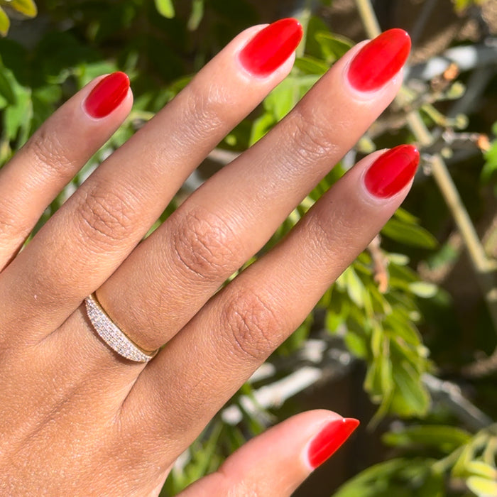 Hand with nails coated in bright red Candy Dipped gel polish showing a fresh manicure by Olive and June