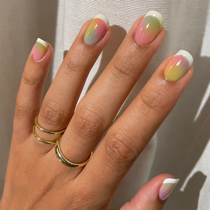 So Lime green with pastel jelly mix-and-match manicure and gold rings in sunlight