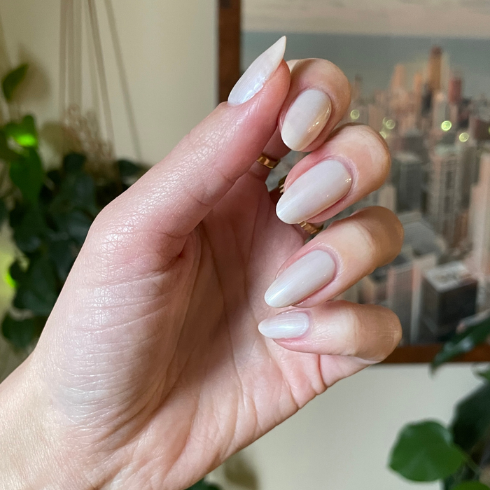 Atlas pearly white gel polish on almond-shaped nails with a smooth, luminous finish for an at-home manicure by Olive and June
