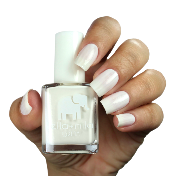 Ballet It On Me milky white nail polish on a medium skin tone, hand holding the bottle