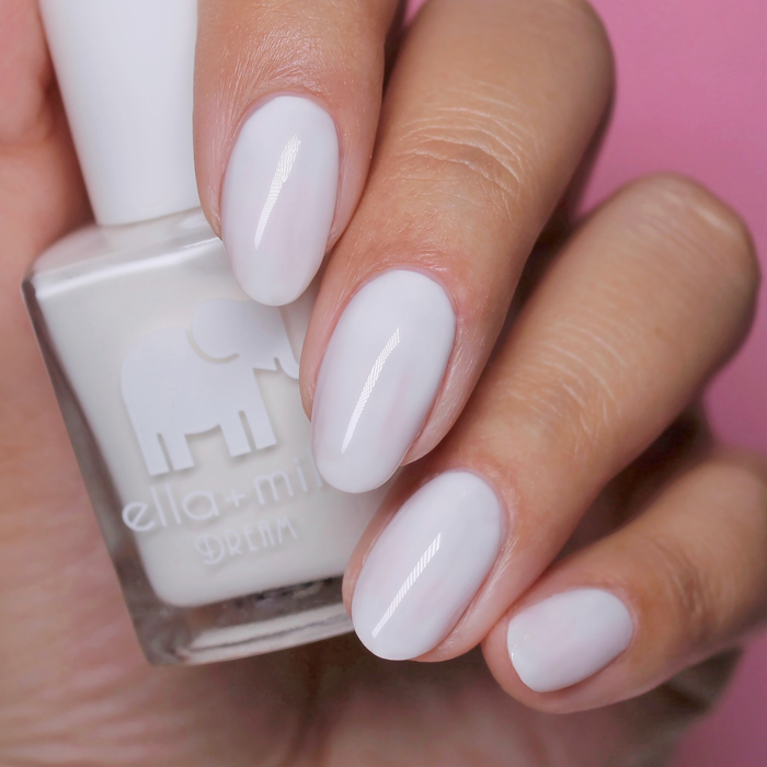Ballet It On Me milky ivory nail polish close-up with the bottle on a pink background
