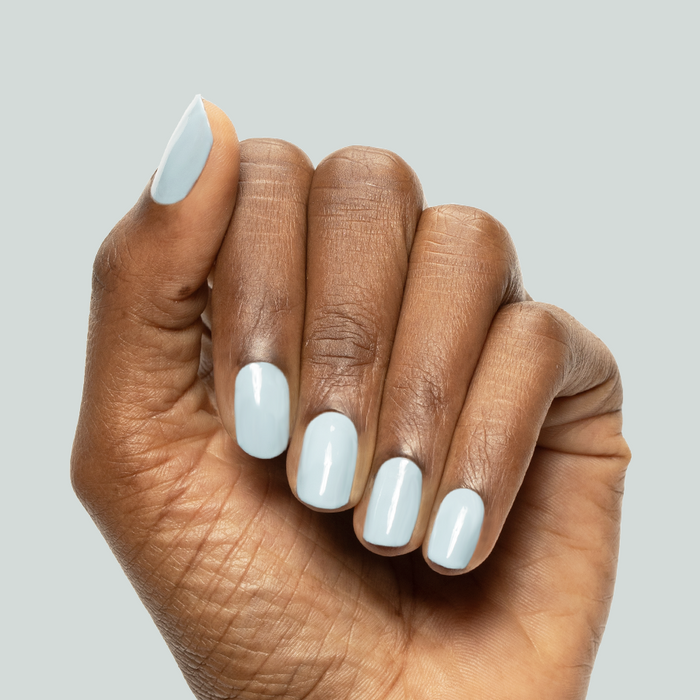 Hand with nails painted in glossy Bandana Blue gel polish showcasing a smooth, long-lasting manicure finish