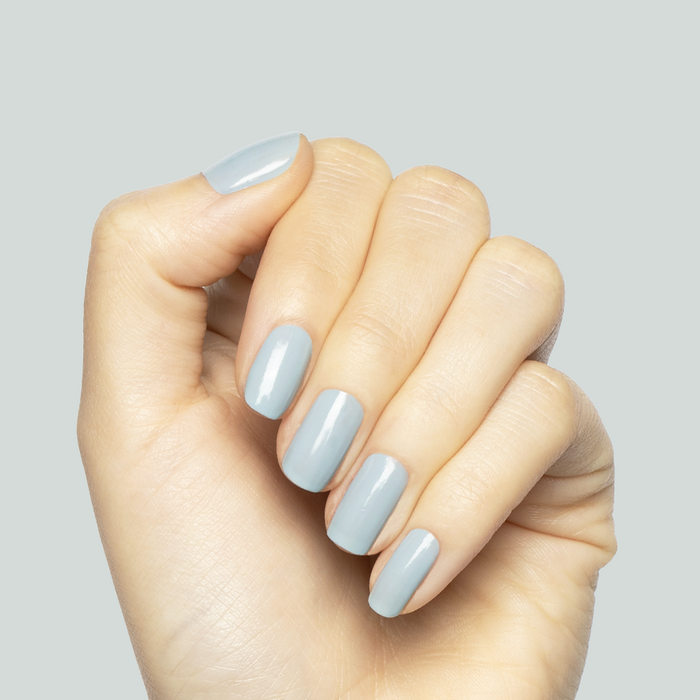 Hand with nails painted in soft pastel Bandana Blue gel polish showcasing a smooth, long-lasting manicure finish