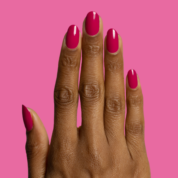 Hand with glossy nails painted in Biggest Bow magenta pink gel polish for a bright at-home manicure
