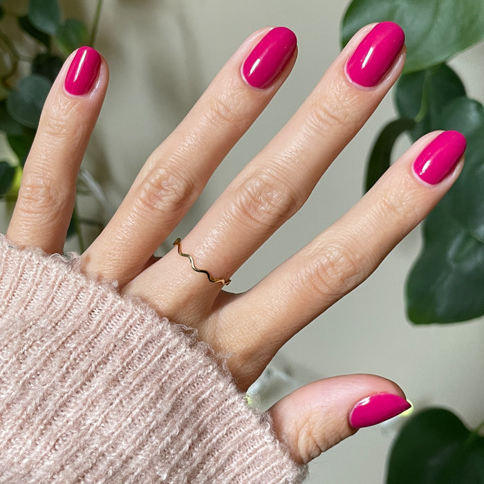 Hand displaying nails painted in glossy Biggest Bow magenta pink gel polish for a vibrant at-home manicure