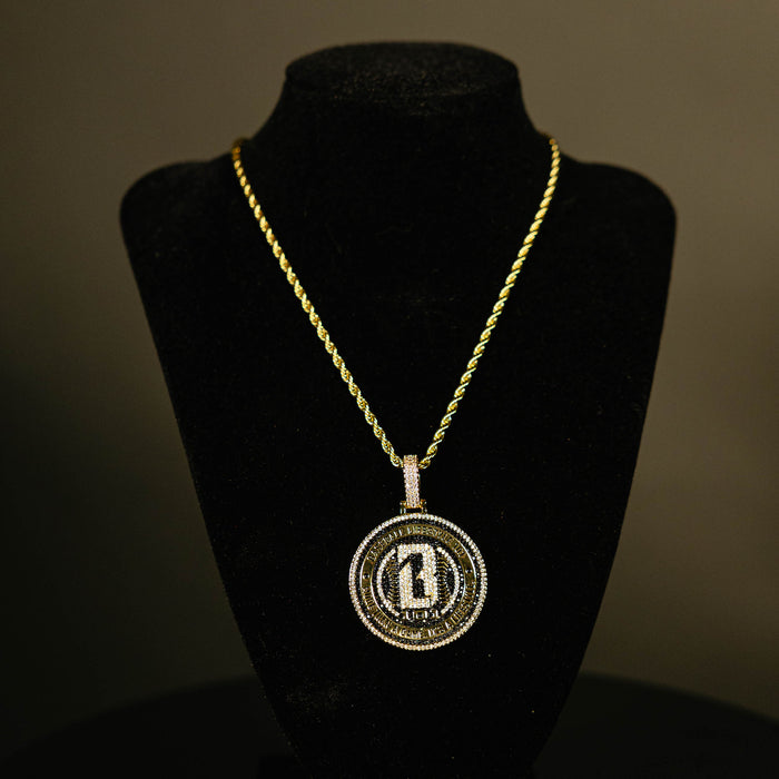 Yellow gold BL101 Medallion necklace hanging on a display stand against a black background