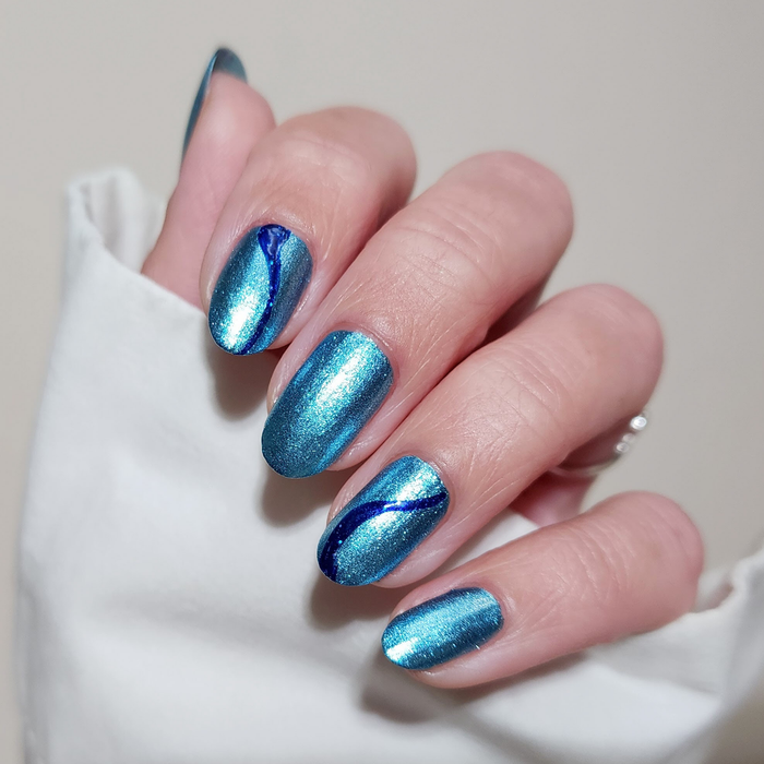 Blue Diamond Dream ice blue sparkle nail polish with blue tip accent nails on a light skin tone