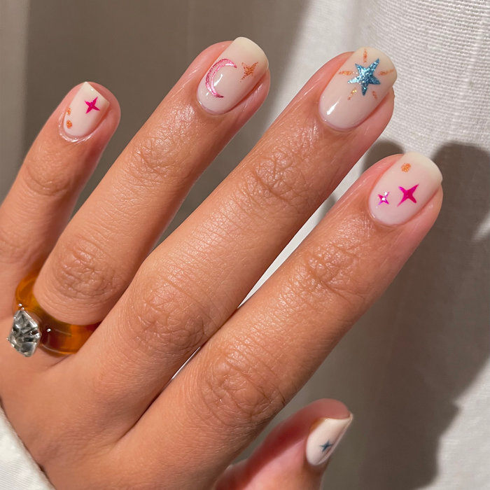 Blue Diamond Dream sparkle accents with red and blue star nail art on a nude manicure
