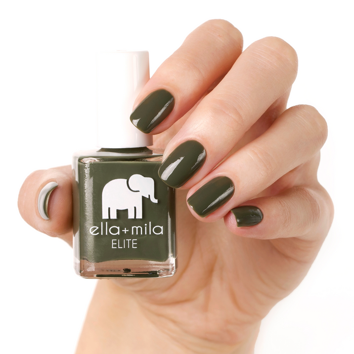 Bon Voyage dark olive green nail polish manicure on a light skin tone with the bottle