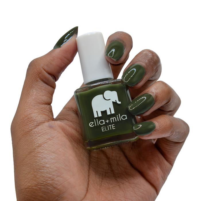 Bon Voyage dark olive green nail polish on a deep skin tone, hand holding the bottle