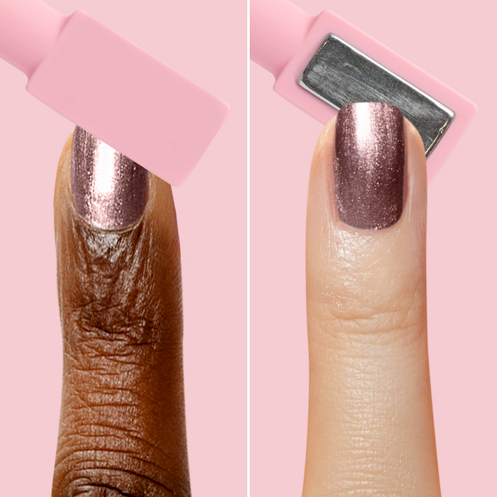Two fingers applying Bronze Velvet magnetic polish with a pink rectangular magnetic wand for shimmering nail effects