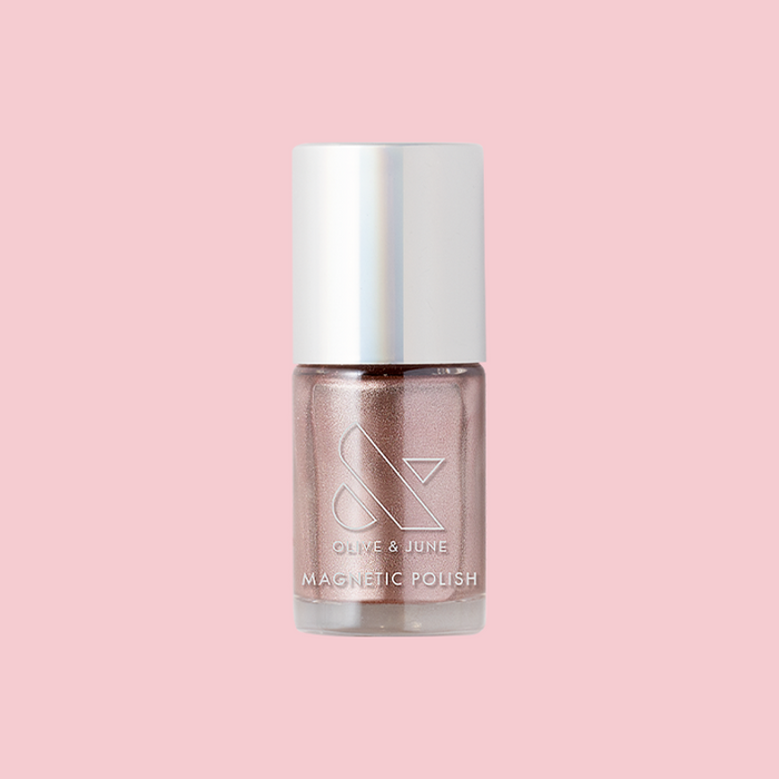 Olive and June Bronze Velvet magnetic polish bottle with shimmery neutral pink shade on a soft pink background