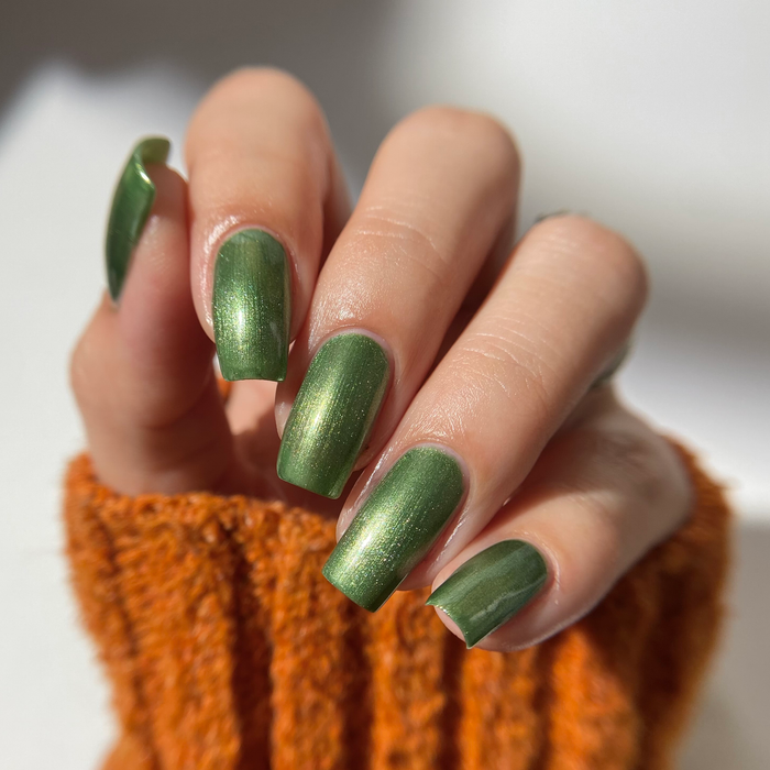 Call Me Jade sage green shimmer nail polish manicure on a light skin tone with an orange sweater