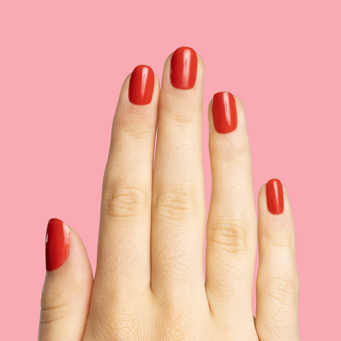 Cherry Chrome Sleigh - Pressies | Extra Short Short | Round showing bright red glossy press-on nails on hand against pink background