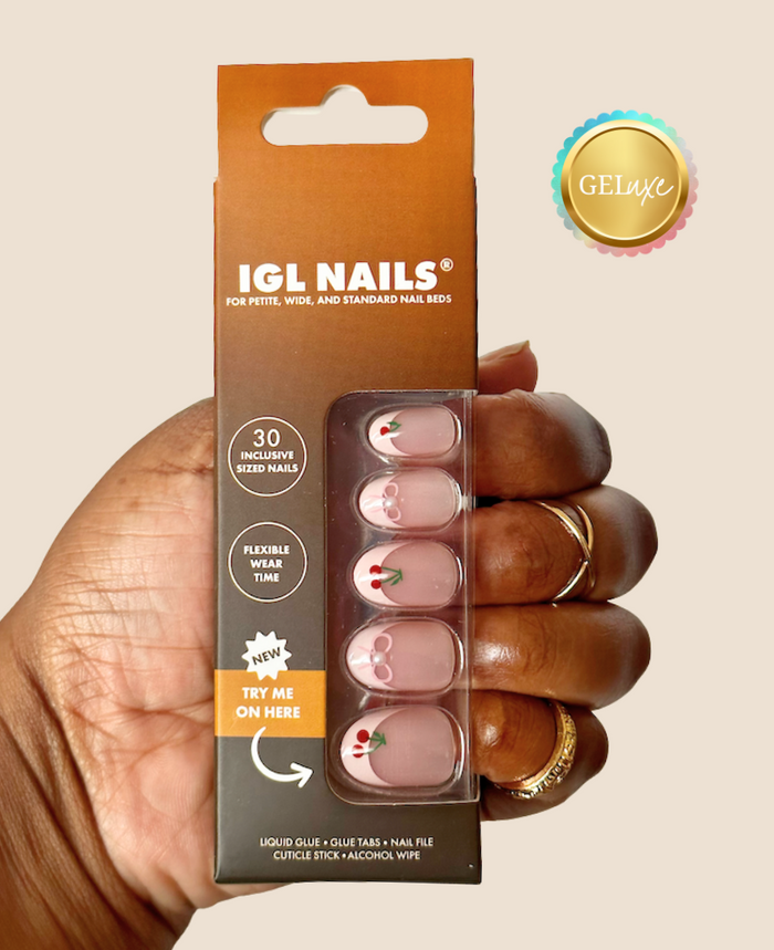Cherry Geluxe press-on nails with pink French tips, cherry and bow accents, and a 3D pearl. Short oval shape, size-inclusive fit.