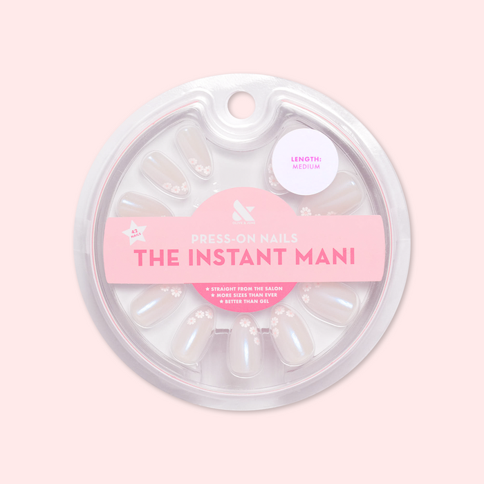 Daisy French - Press-On | Medium | Almond showing medium almond false nails with delicate white daisy design in circular packaging