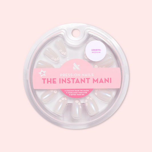 Daisy French - Press-On | Medium | Almond showing medium almond false nails with delicate white daisy design in circular packaging