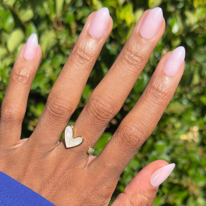 Hand with medium almond shaped nails in milky sheer pink wearing Dream Job - Press-On | Medium | Almond from Olive and June