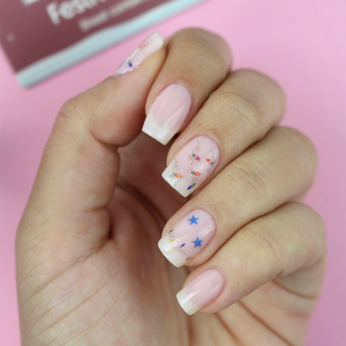 Festival of Lights star and dreidel decals on a sheer pink manicure with the packaging
