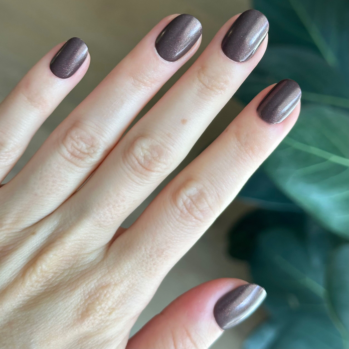 Hand showing Goal Getter - Tab Press-On | Extra Short | Round nails in chocolatey neutral with golden shimmer for an easy at-home mani