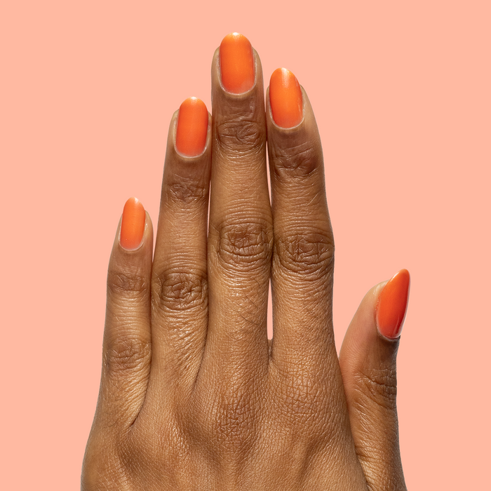 Hand with matte nails painted in I’ll Take Another Spritz for a bright, long-lasting at home mani look