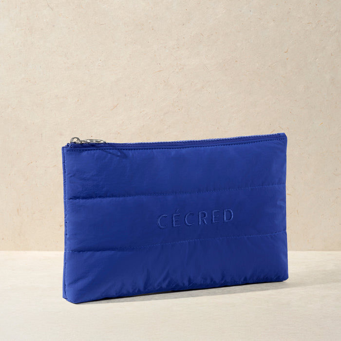 Blue pouch with 'Cécred' branding on a beige background