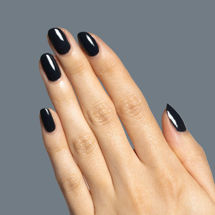 Hand with glossy deep charcoal gray nails polished in Last Minute Shopping for sleek at-home manicure by Olive and June