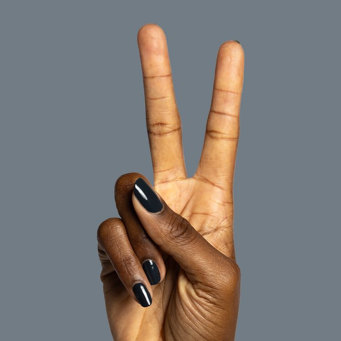 Hand with glossy deep charcoal gray nails painted in Last Minute Shopping polish for manicure by Olive and June