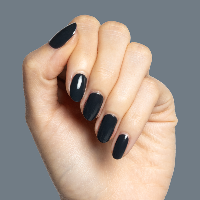 Hand with glossy deep charcoal gray nails polished in Last Minute Shopping gel polish for an at-home manicure
