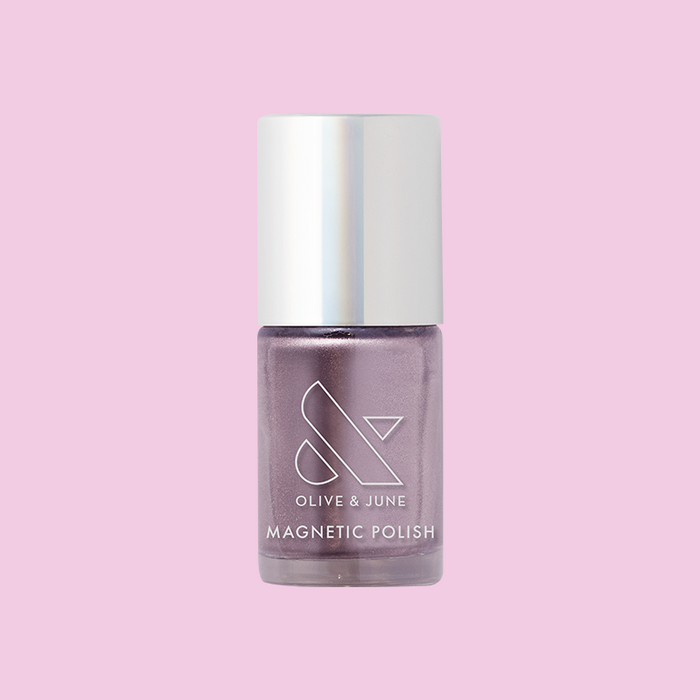 Olive and June Lavender Velvet magnetic polish bottle in frosty purple shade on a pink background for at-home mani.