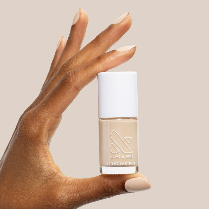 Hand holding Line Dancing Boots polish showing neutral toasted cream shade for long-lasting mani or pedi