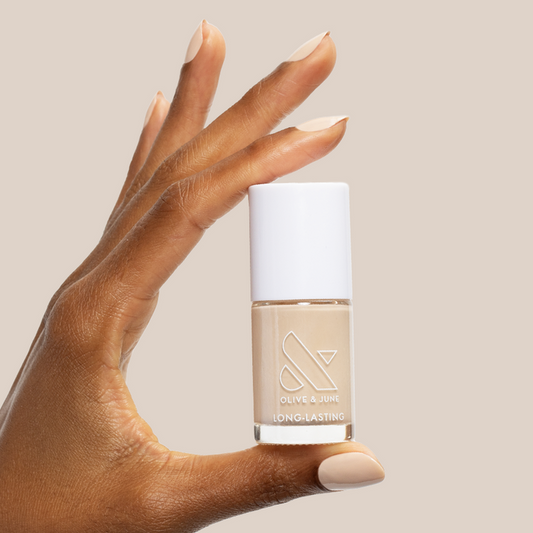 Hand holding Line Dancing Boots polish showing neutral toasted cream shade for long-lasting mani or pedi