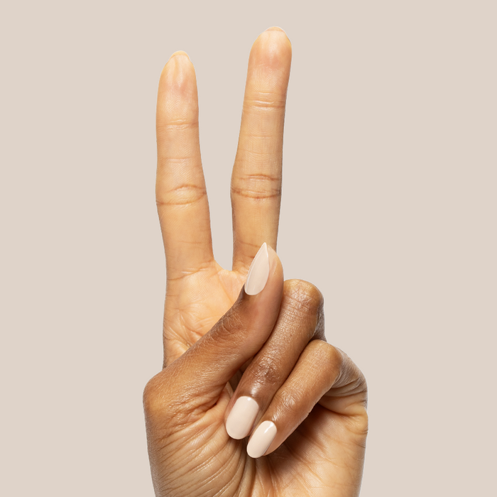 Hand showing peace sign with glossy neutral toasted cream nails painted using Line Dancing Boots polish for mani or pedi