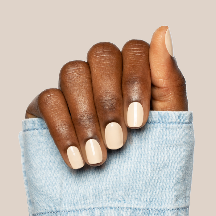 Hand with nails painted in neutral toasted cream shade showing a manicure with Line Dancing Boots polish