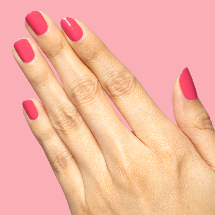 Hand with neatly painted nails in bright hot pink Love All polish for a vibrant at-home manicure look
