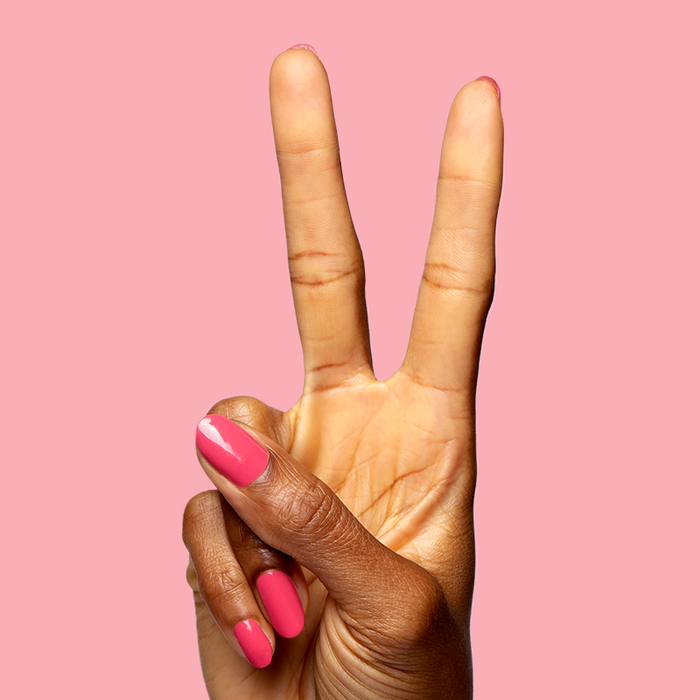 Hand with polished nails in vibrant bright hot pink Love All for a fresh and playful manicure look