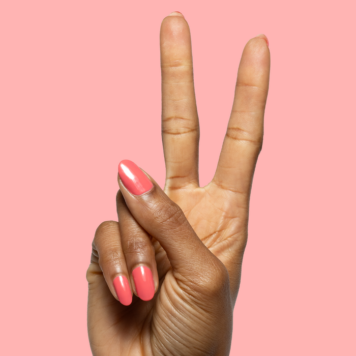 Hand showing peace sign with nails painted in glossy Maine Character Energy gel polish for a vibrant manicure look