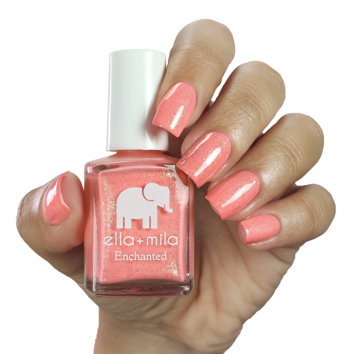 Mystical coral shimmer nail polish manicure on a light skin tone with the bottle