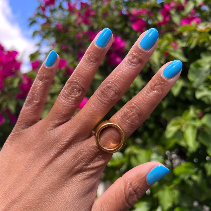Hand with nails painted bright azure blue using Not a Cloud gel polish for a fresh at home manicure