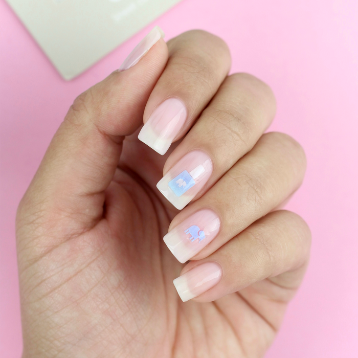 On Brand elephant decals on a sheer nude manicure with the packaging
