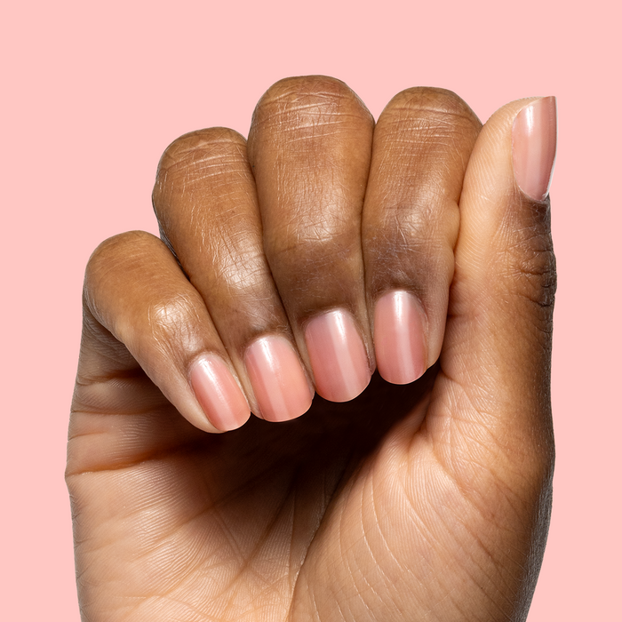 Hand displaying glossy warm peach pink nails with Pink Pineapple Gloss for a subtle at-home mani