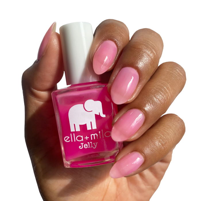 Pink Sand Beach bright pink jelly nail polish on a deep skin tone, hand holding the bottle