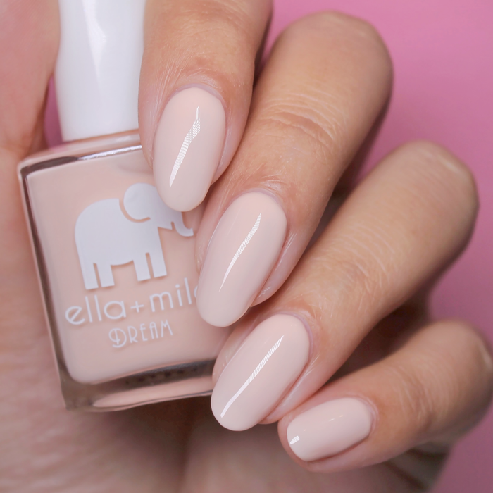 Pirouette warm nude pink nail polish close-up with the bottle on a pink background