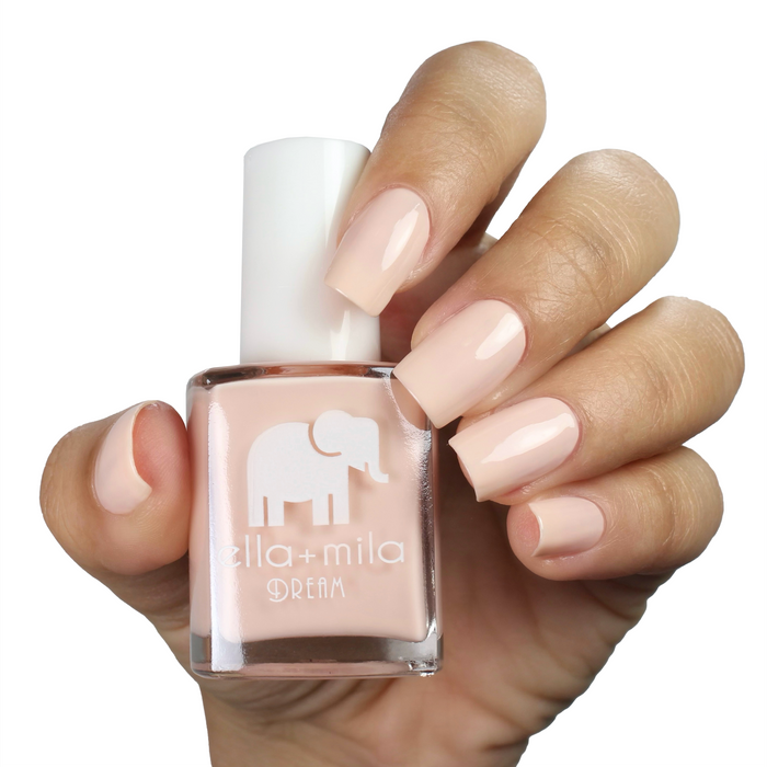 Pirouette nude pink nail polish on a medium skin tone, hand holding the bottle