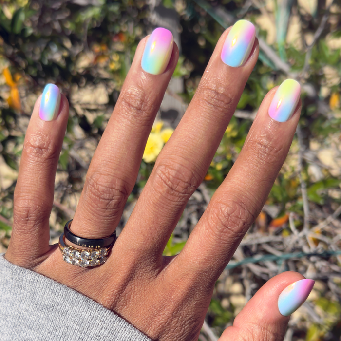 Rainbow Aura Chrome - Press-On | Short | Round pastel rainbow gradient press-on nails shown on hand in natural sunlight outdoors