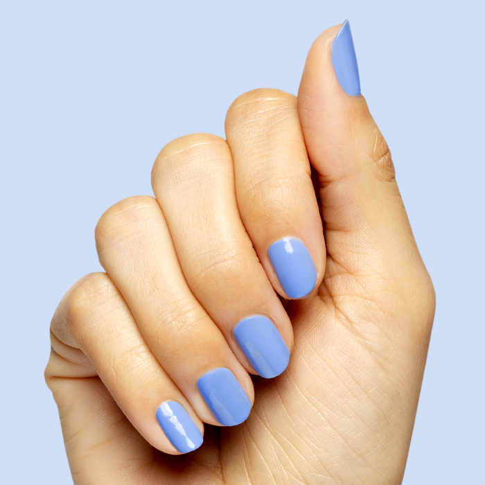 Hand with smooth nails coated in Rally Ready polish, a dusty ultramarine blue for a fresh at-home manicure look