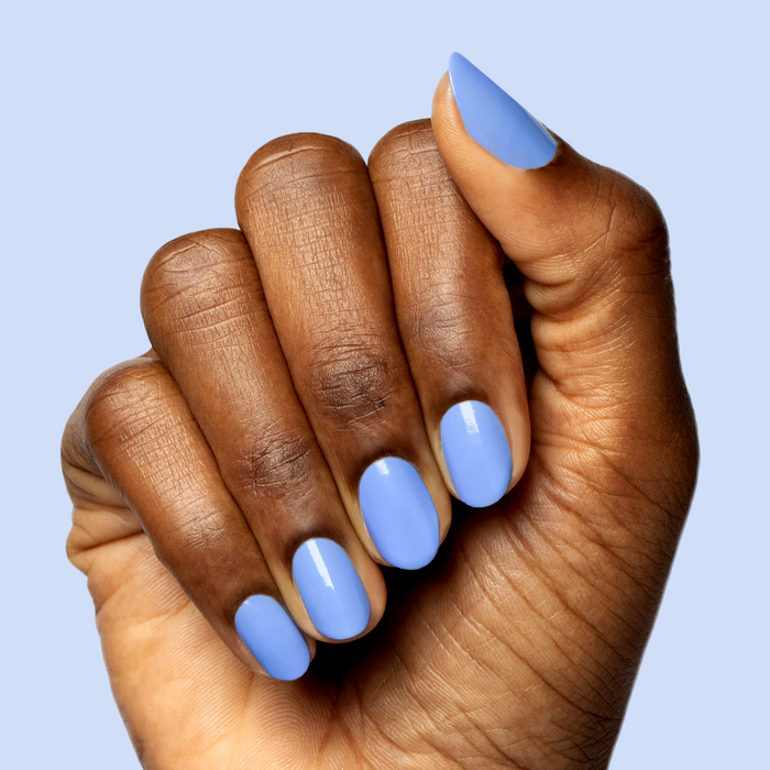 Hand with smooth nails coated in glossy Rally Ready polish, a dusty ultramarine blue for a sporty mani look