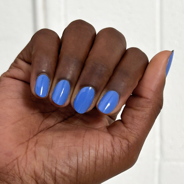 Fingernails painted with glossy Rally Ready polish in dusty ultramarine blue for a sleek at-home manicure