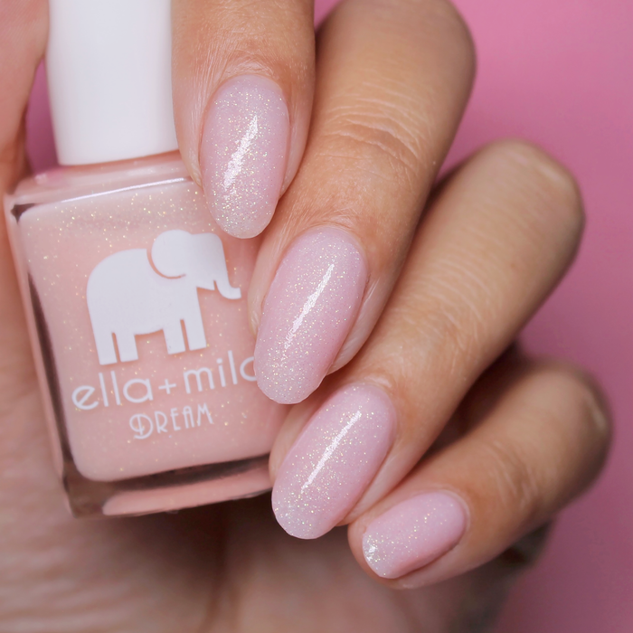 Relevé translucent pink shimmer nail polish close-up with the bottle on a pink background